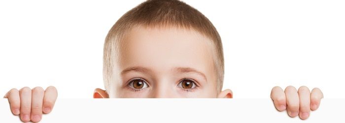 blonde male child peaking over a ledge